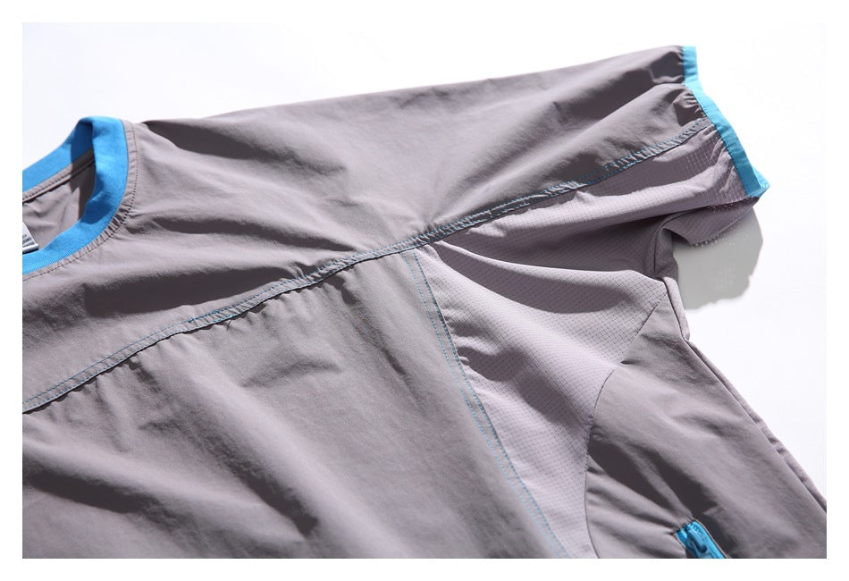 Flat-lay front view of a gray short-sleeve top with a bright blue crew neck, sleeve trim, and mesh side panels.