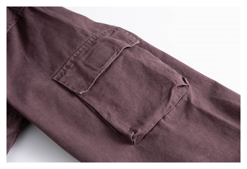 Close-up of a dusty mauve garment with a stitched flap pocket.