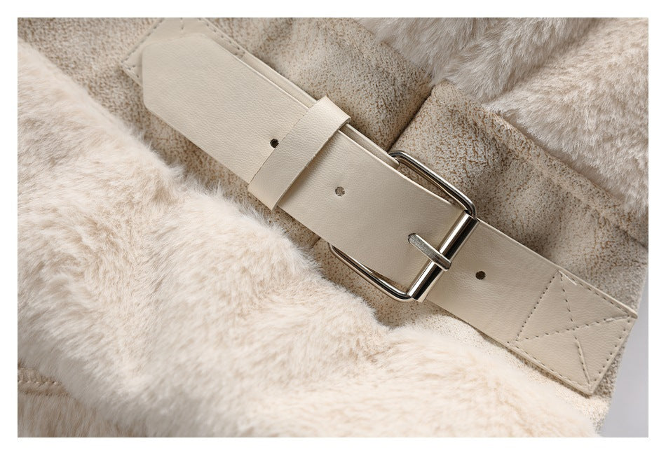 Close-up of a cream coat belt with a silver buckle against plush and suede-like panels.