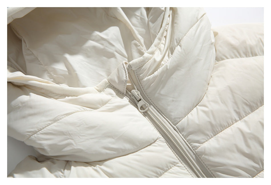 Close-up of the ivory jacket's hood opening and front zipper with ring-shaped pull.