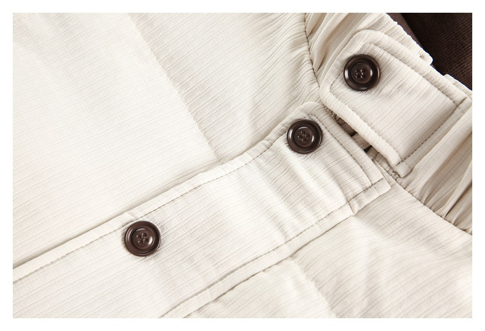 Close-up of the ivory jacket's textured fabric and brown buttons at the front and cuff.