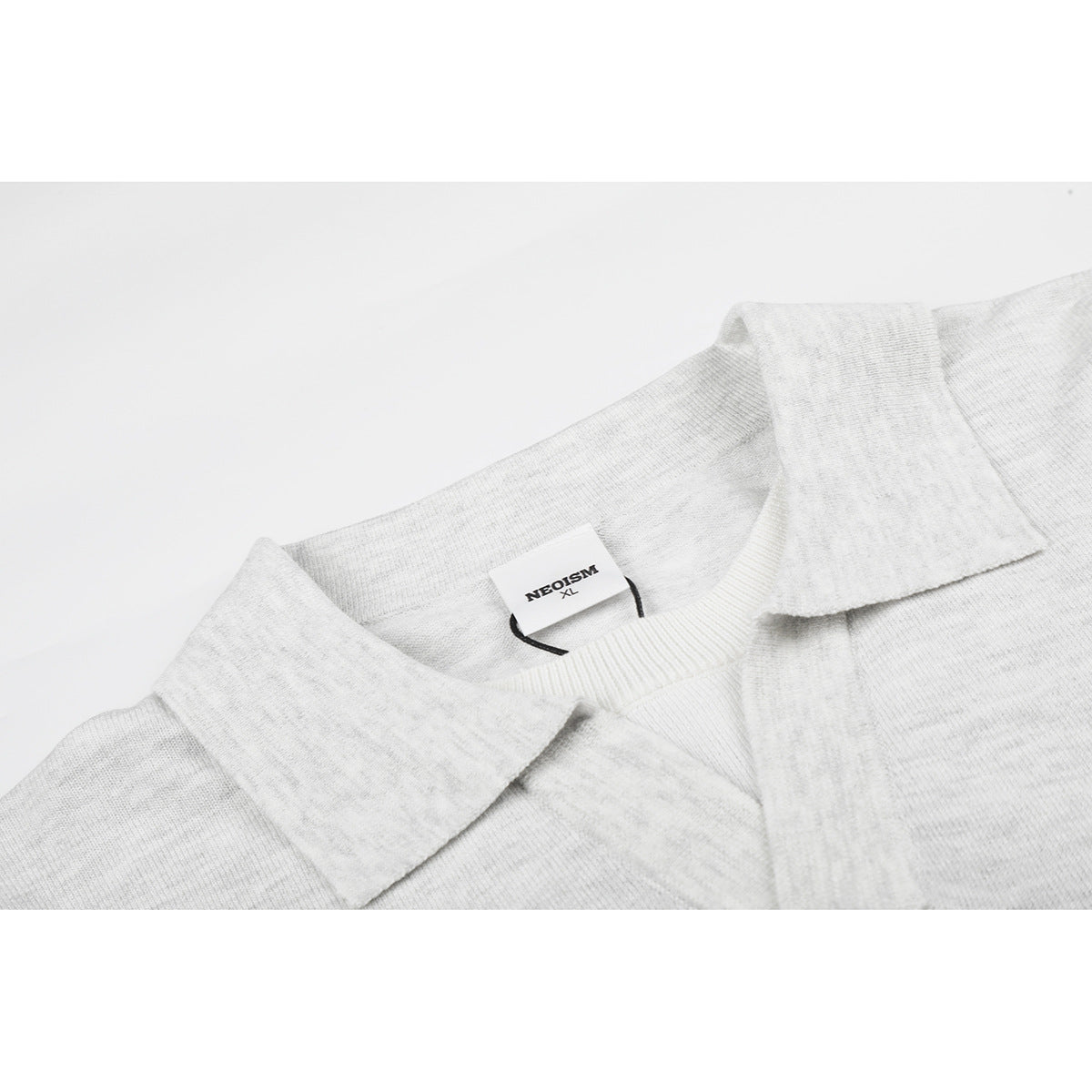 Close-up of a light gray knit polo collar and neckline with a NEOSM XL neck label.