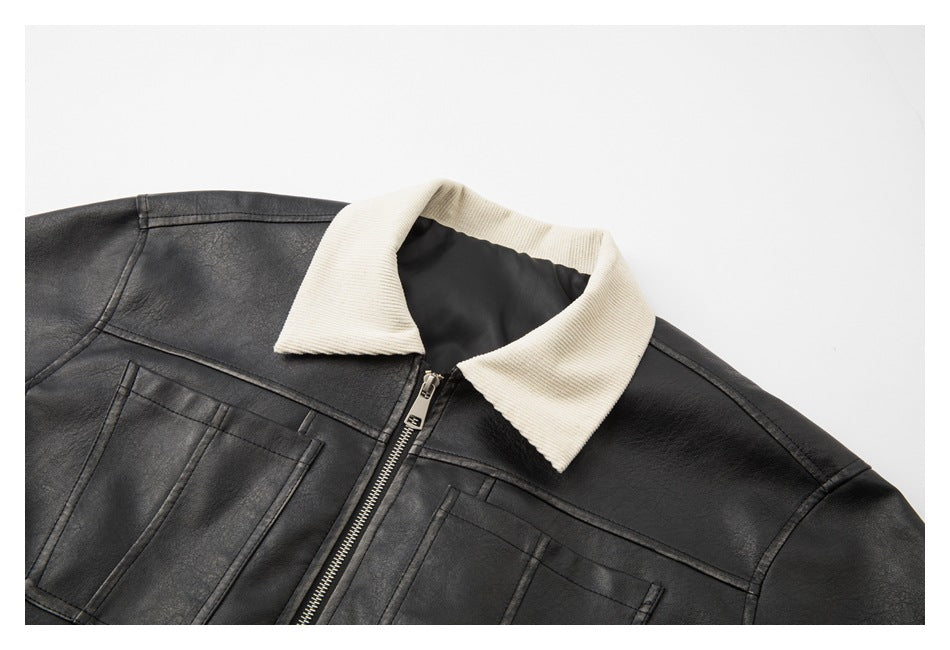 Close-up of a black jacket with a cream ribbed collar, front zipper, and stitched chest pockets.