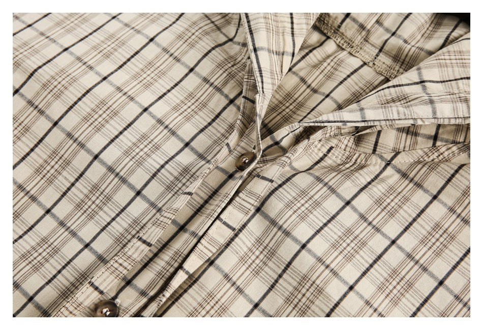 Close-up of a cream plaid shirt's hood opening, button placket, and brown buttons.