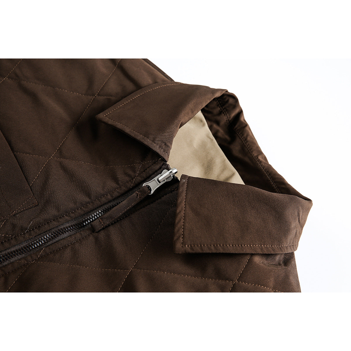 Close-up of a dark brown quilted jacket collar, zipper, stitching, and beige lining.