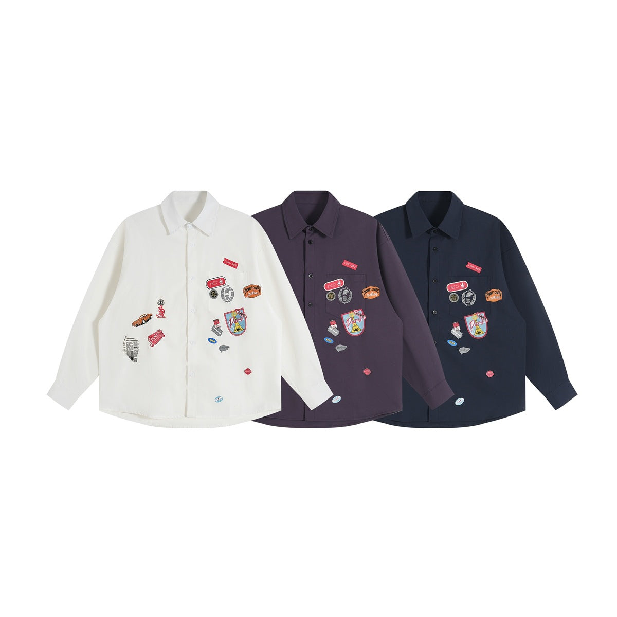 Three front-view long-sleeve button-up shirts in white, muted purple, and dark navy with colorful chest graphics.