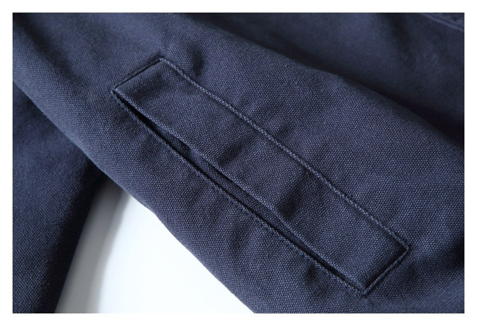 Close-up of a long rectangular stitched pocket on dark navy fabric.