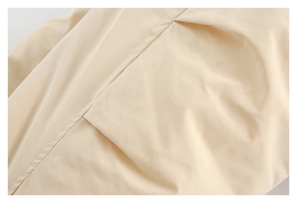 Close-up of a cream garment's stitched seam and smooth surface.