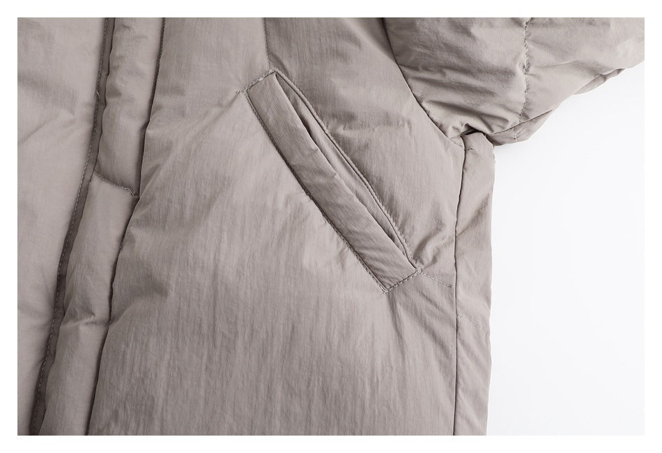 Close-up of a diagonal welt pocket on the taupe padded jacket.