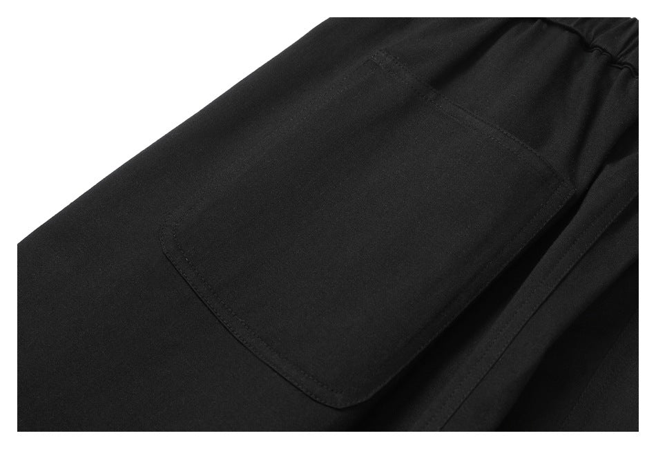 Close-up of a large patch pocket on black trousers.