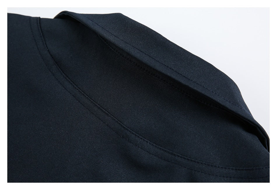 Close-up of a dark navy garment neckline and curved stitched seam.