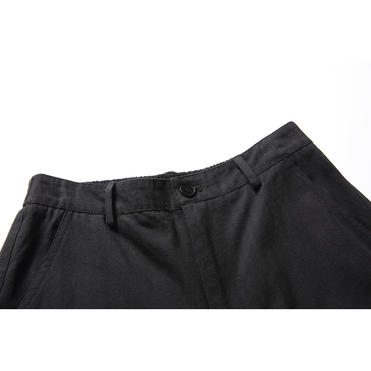 Close-up of black shorts waistband with a button, belt loops, and front pleats.