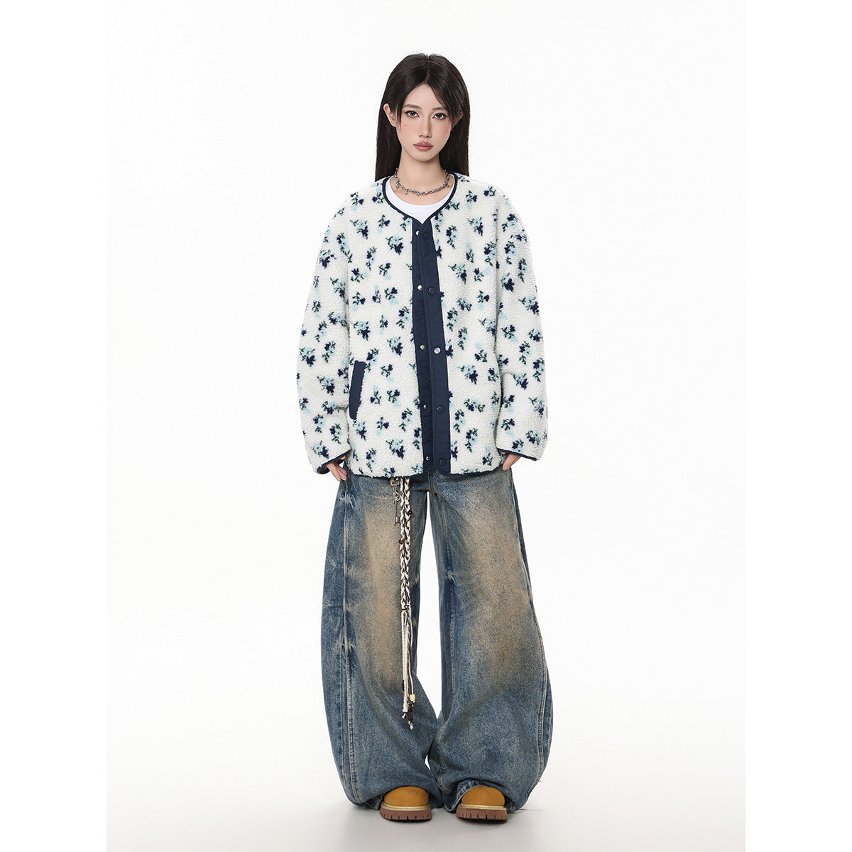 Full-length model wearing a white floral fleece jacket with navy trim and loose blue jeans.
