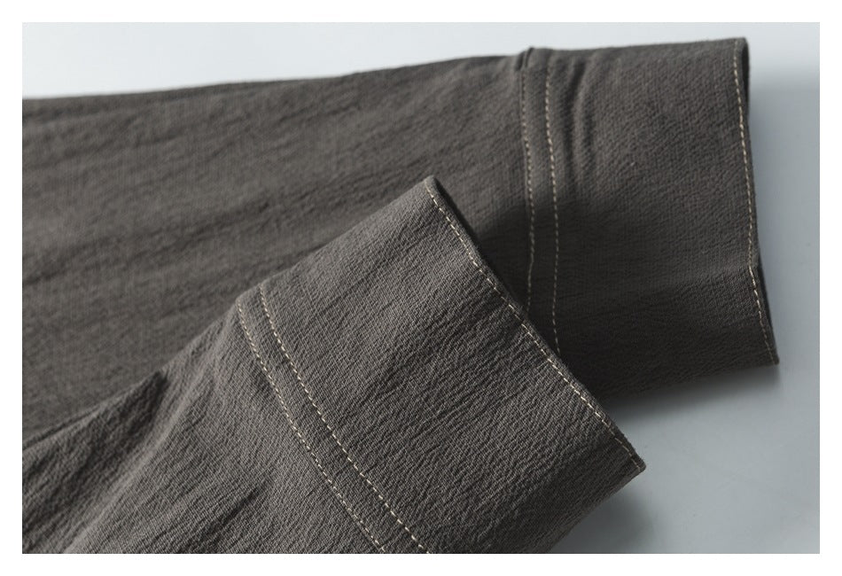 Close-up of dark charcoal garment cuffs with light contrast stitching.