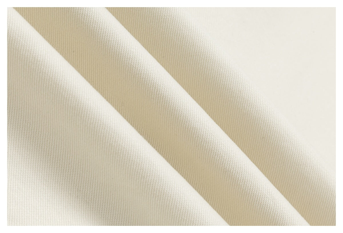 Macro view of the ivory garment's textured woven surface.