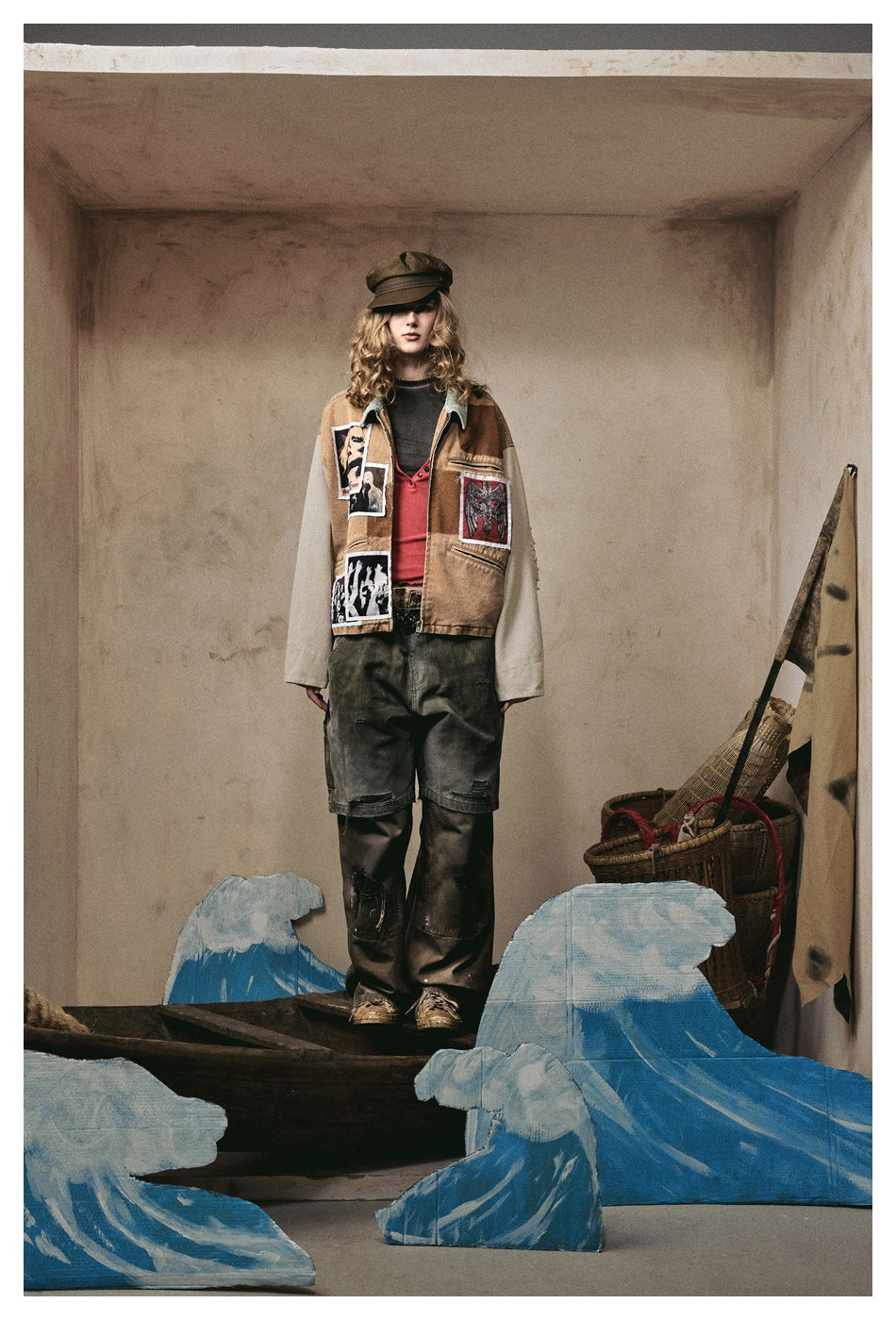 Model wearing the patchwork cropped jacket with red top, dark cargo pants and cap, front view in a styled set