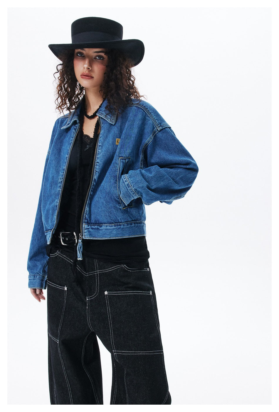 Model in a blue denim zip jacket, shown at an angle with a pointed collar and front pockets.