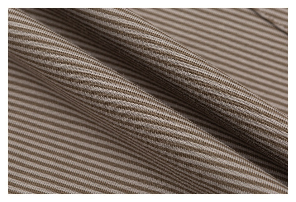 Close-up of beige and brown striped fabric draped into soft folds.