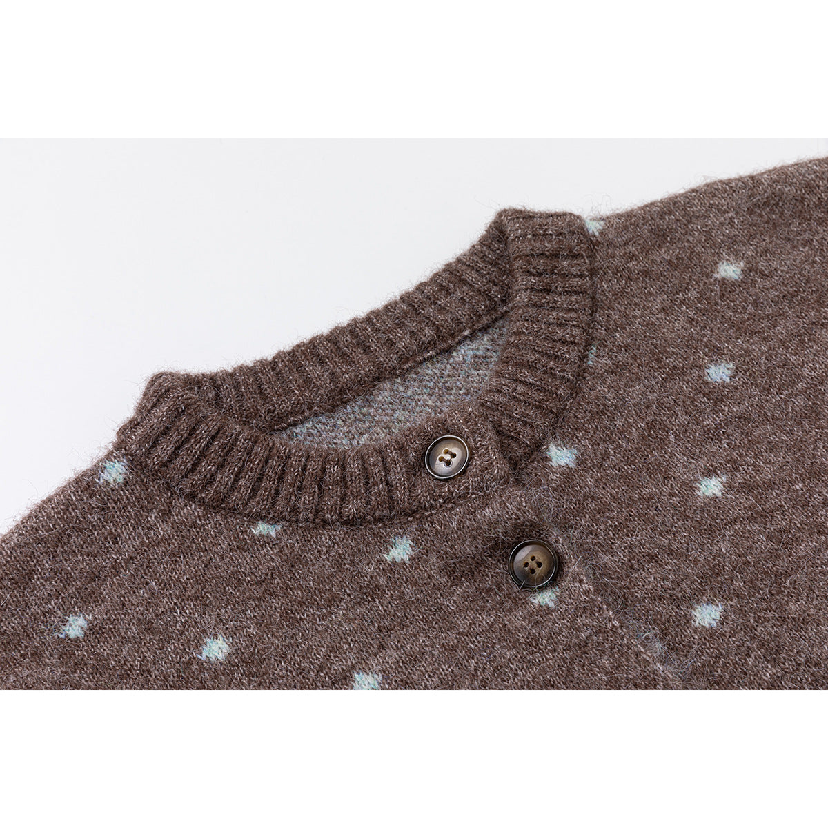 Close-up of a brown knit cardigan neckline with pale blue dots, ribbed trim, and two dark buttons.