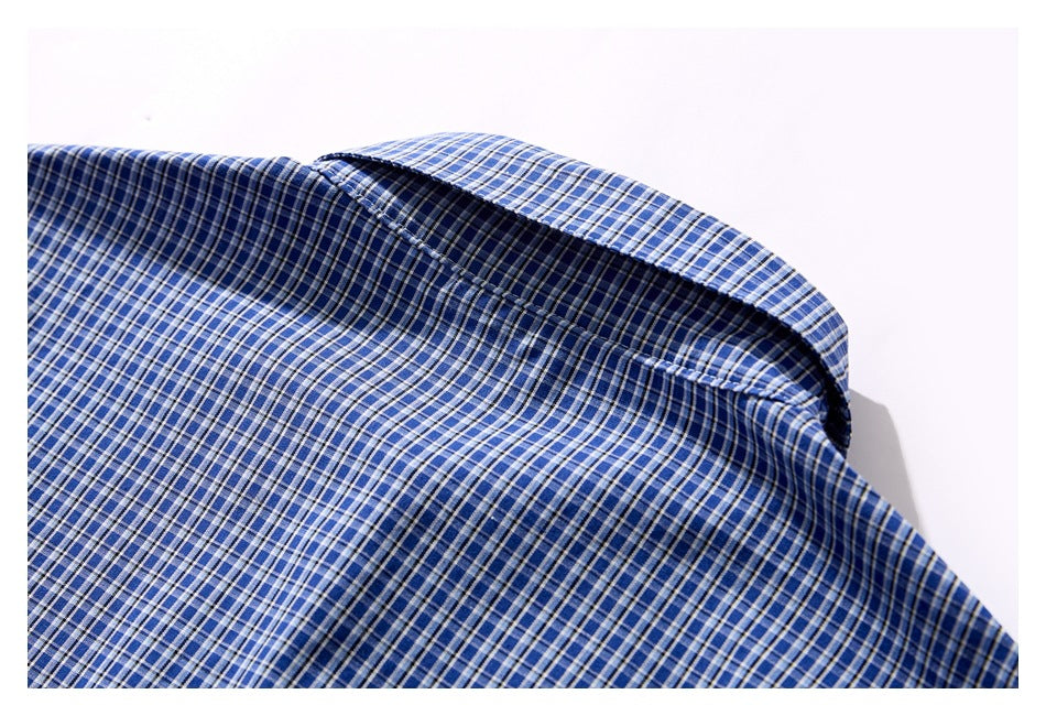 Close-up of a blue, navy, and white checked shirt collar and fabric.