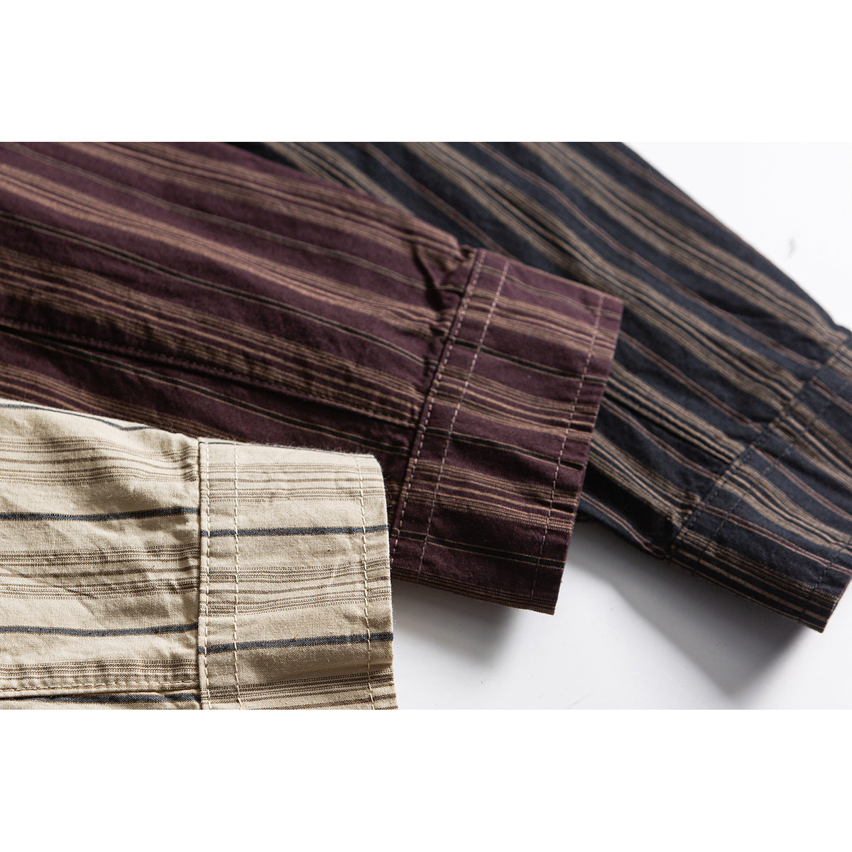 Close-up of striped shirt cuffs in burgundy, charcoal, and beige colorways.