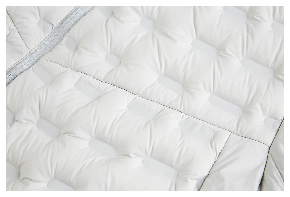 Close-up of the white jacket's quilted panels, stitching, and edge of a gray zipper.