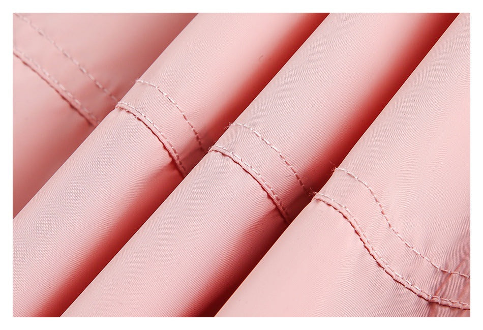 Close-up of folded pale pink garment fabric showing stitched seam edges.