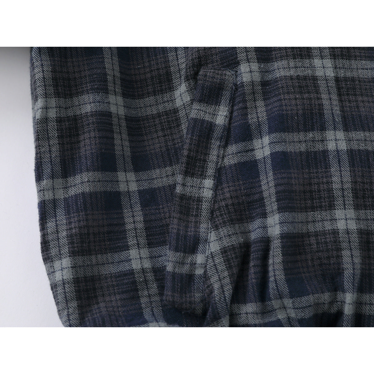 Close-up of the dark blue and gray plaid jacket fabric and a folded seam.