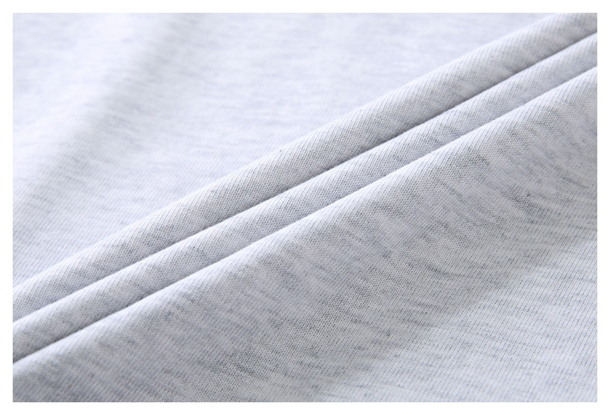 Close-up of the heathered surface and draped folds of light gray T-shirt fabric.