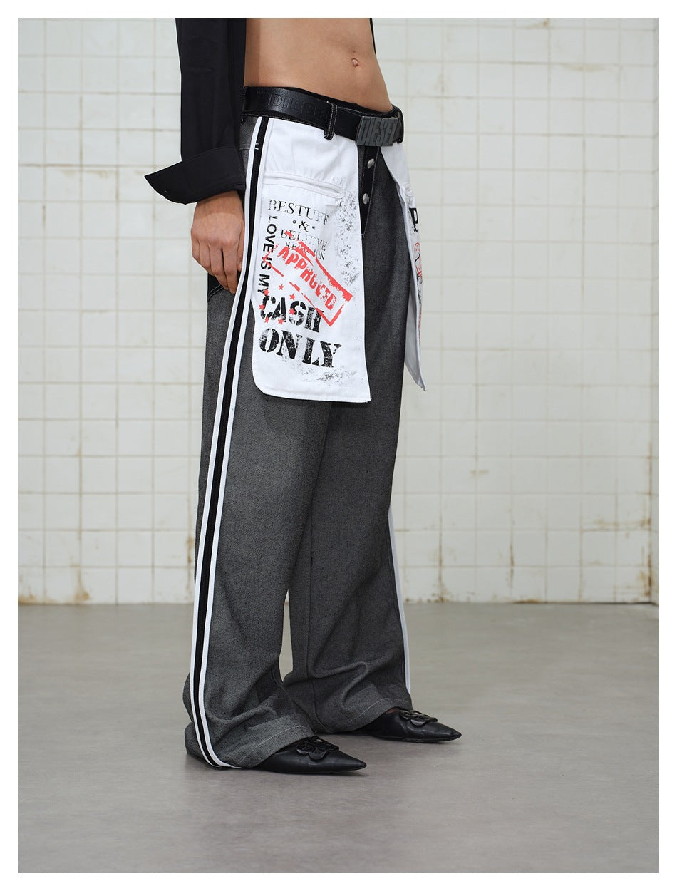 Side view of a model wearing wide gray trousers with white printed panels and contrasting white side stripes.