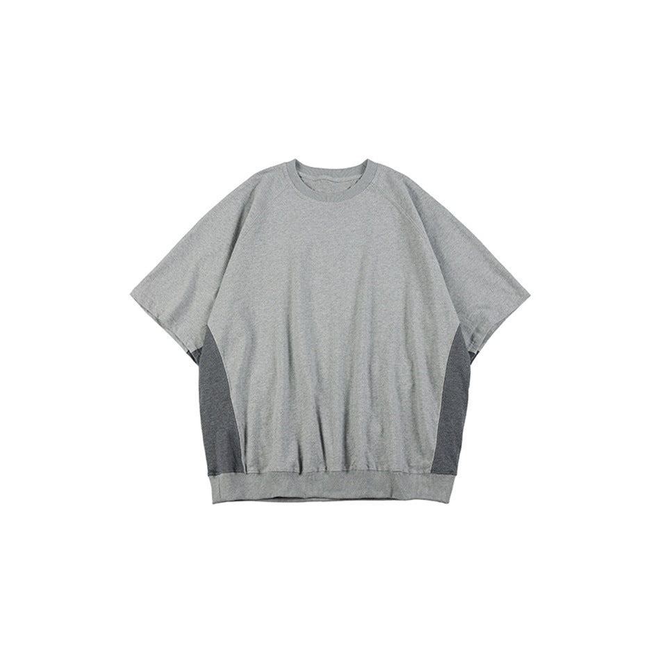 Flat-lay front view of an oversized light gray short-sleeve sweatshirt with dark gray side panels and a ribbed hem.