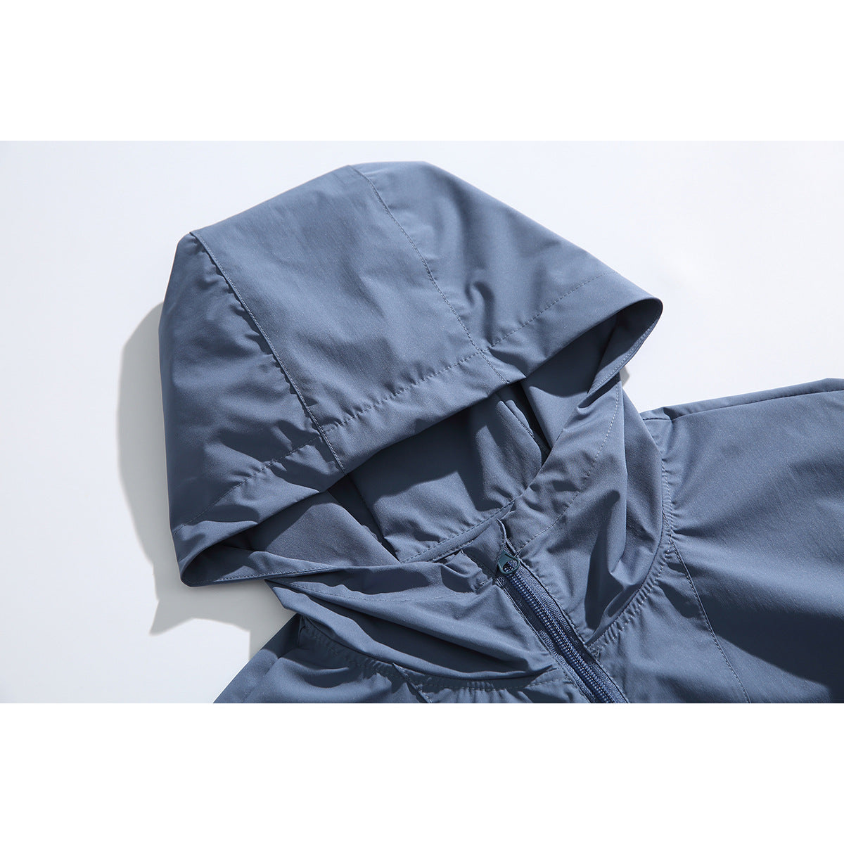 Close-up of a slate-blue hood, neckline and short front zipper on a hooded pullover.