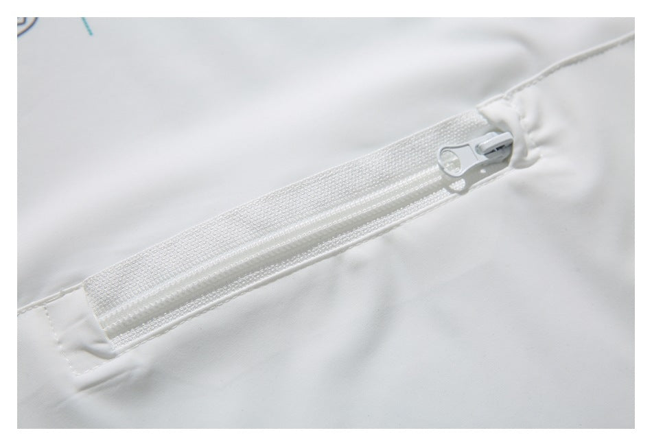 Close-up of a white zipper and pull on white fabric.