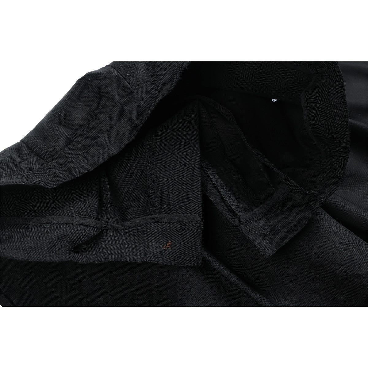 Close-up of the inside of black trousers, showing the waistband lining and finished seams.