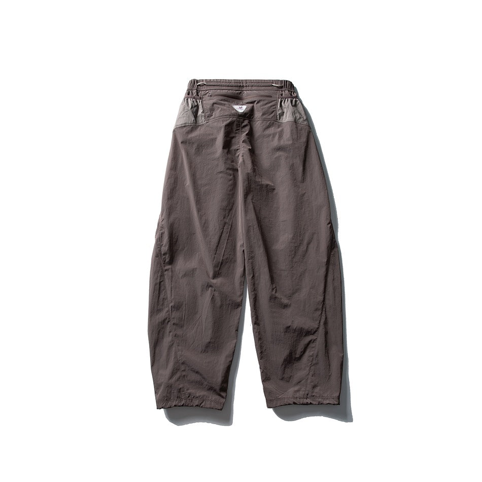 Back view of taupe wide-leg pants with a gathered waist and lighter contrasting panels across the hips.