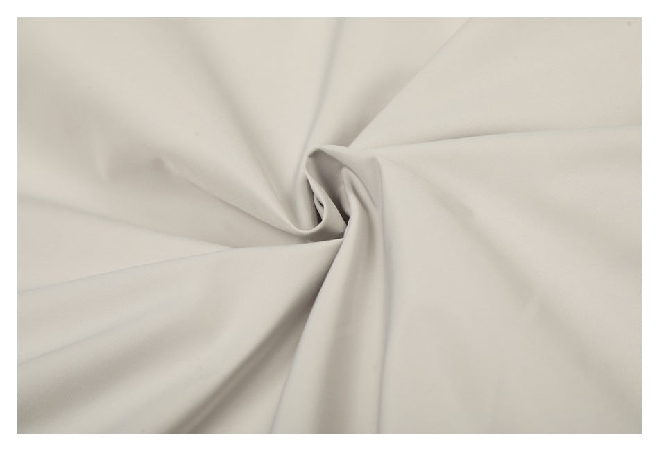 Close-up of light beige fabric draped into soft folds.