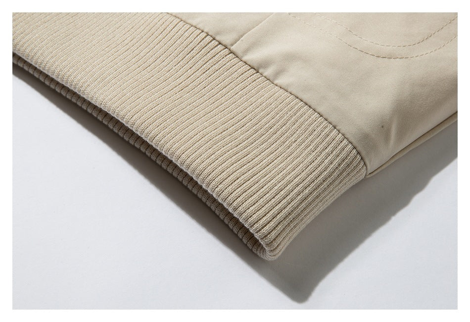 Close-up of a beige garment's wide ribbed knit cuff or hem.