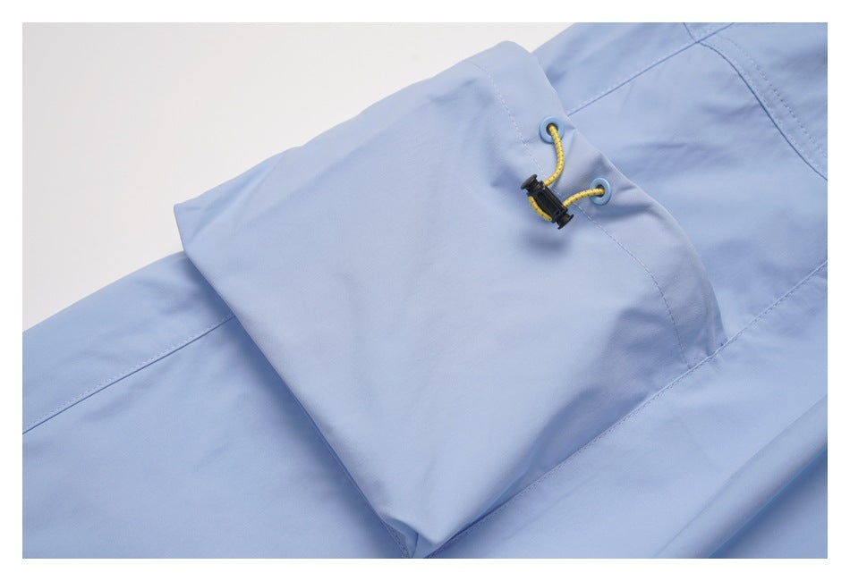 Close-up of the skirt's light blue pocket flap with yellow cord and black toggle fastener.