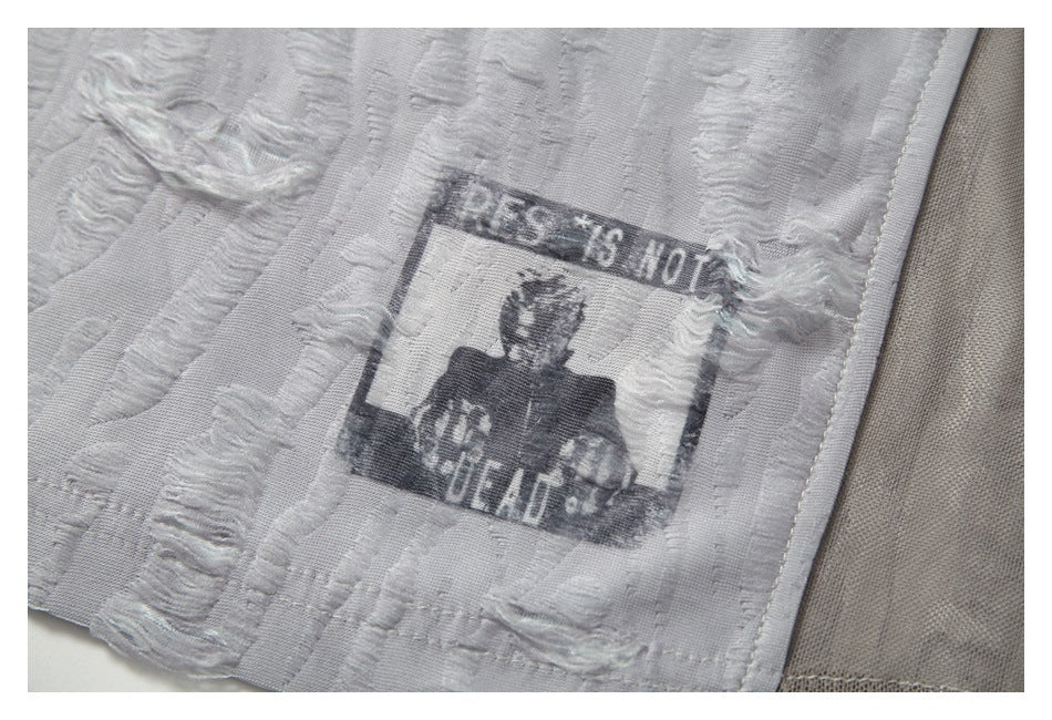 Close-up of a distressed black portrait and English text printed on the light gray fabric.