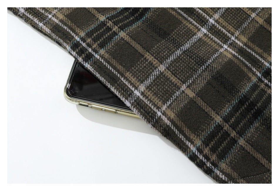 Dark brown plaid shirt fabric draped over a smartphone, showing the check pattern.