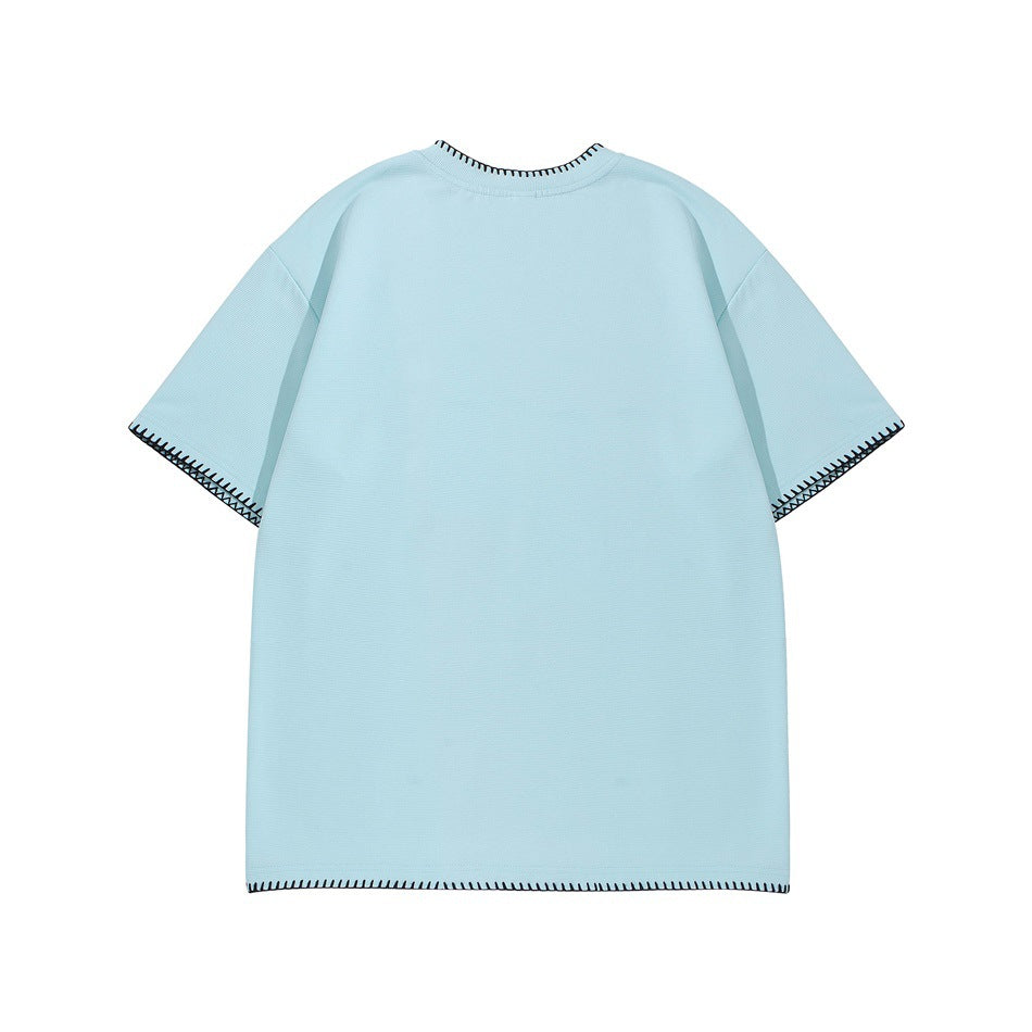 Back view of a pale blue short-sleeve shirt with black contrast stitching at the collar, cuffs, and hem.