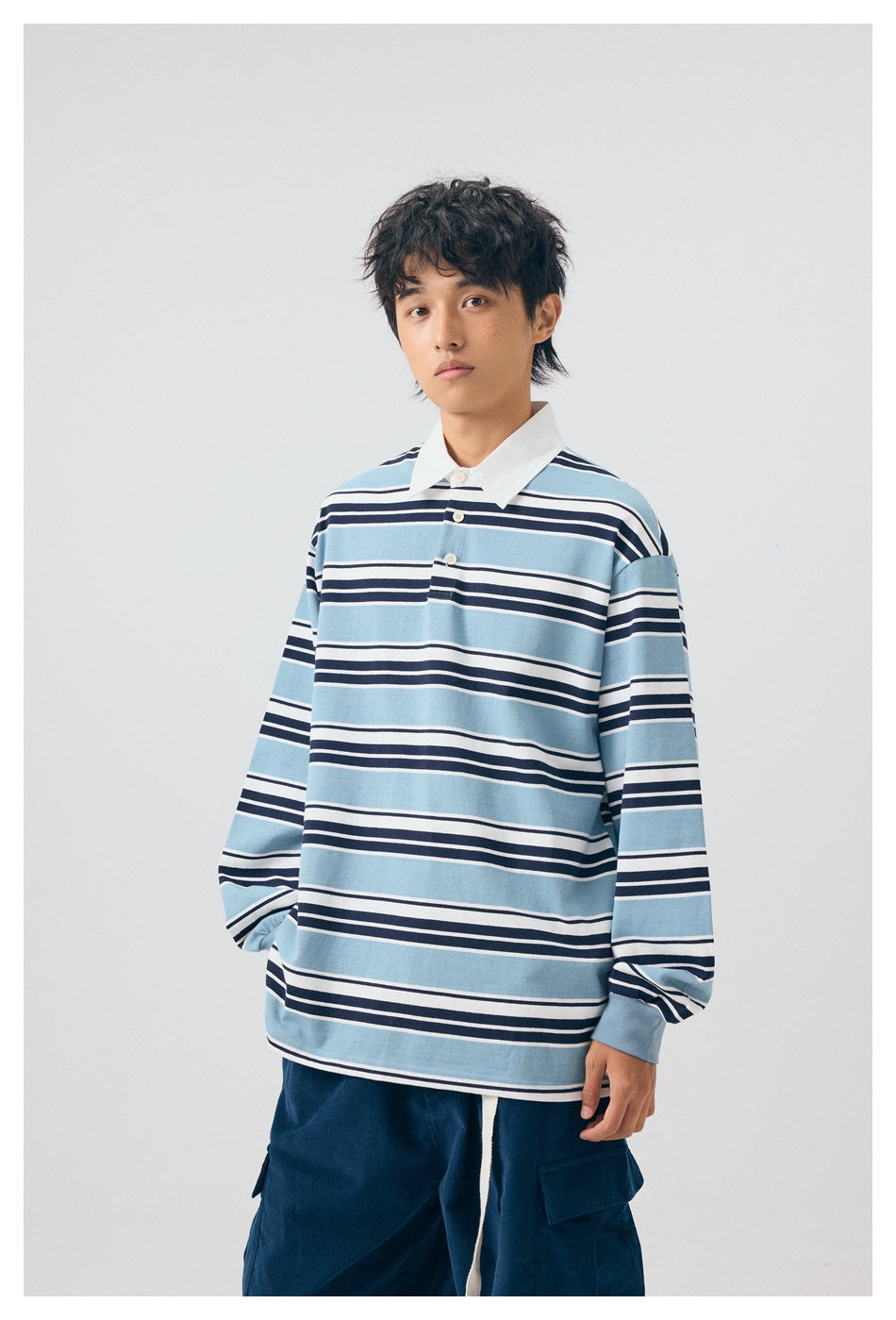 Front view of a model wearing a blue, white, and navy striped long-sleeve collared shirt.