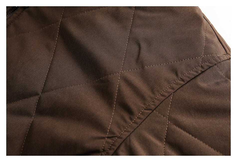 Close-up of dark brown jacket fabric with geometric quilting and curved stitched seam details.