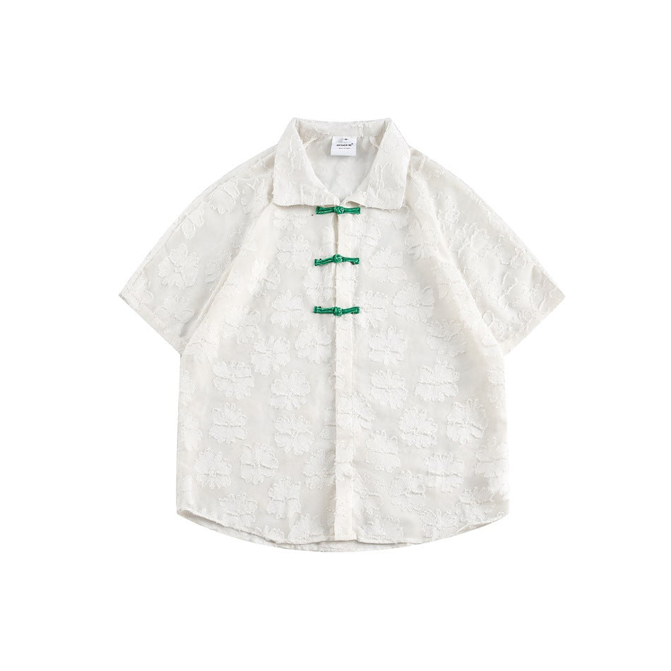 White short-sleeve shirt with raised floral texture and three green knotted closures, flat lay front view
