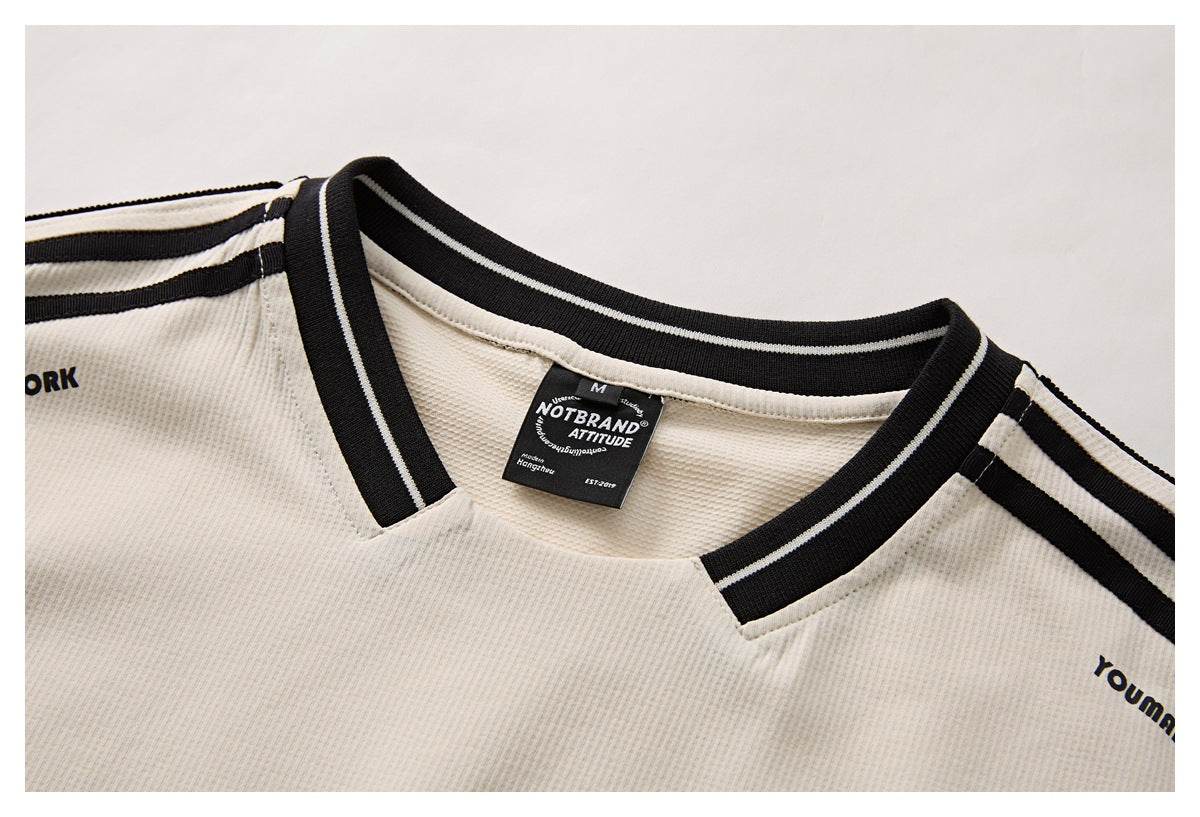 Close-up of the ivory shirt’s striped V-neck, shoulder trim, and inside neck label.