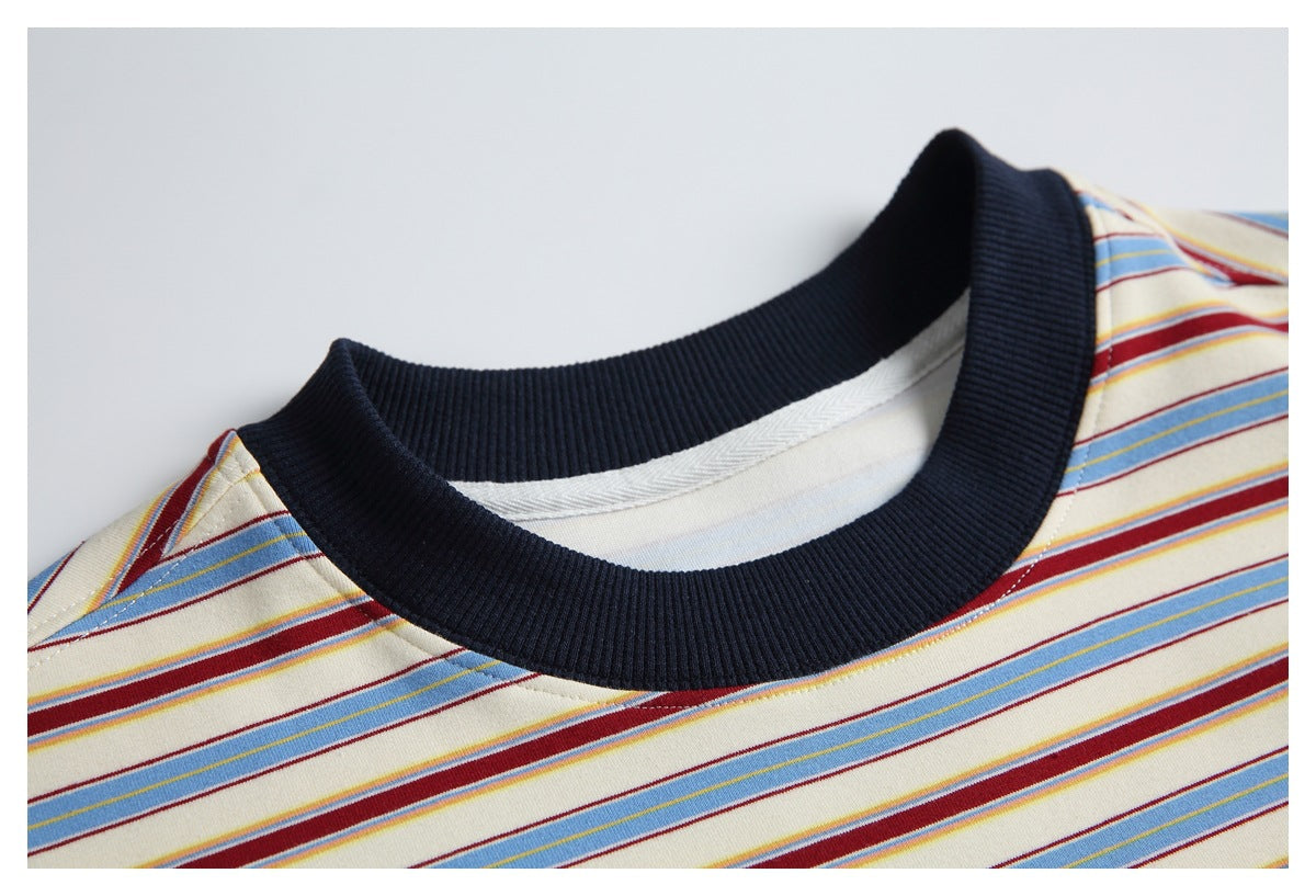 Close-up of the T-shirt's dark ribbed crew neck against its cream, blue, and burgundy striped fabric.