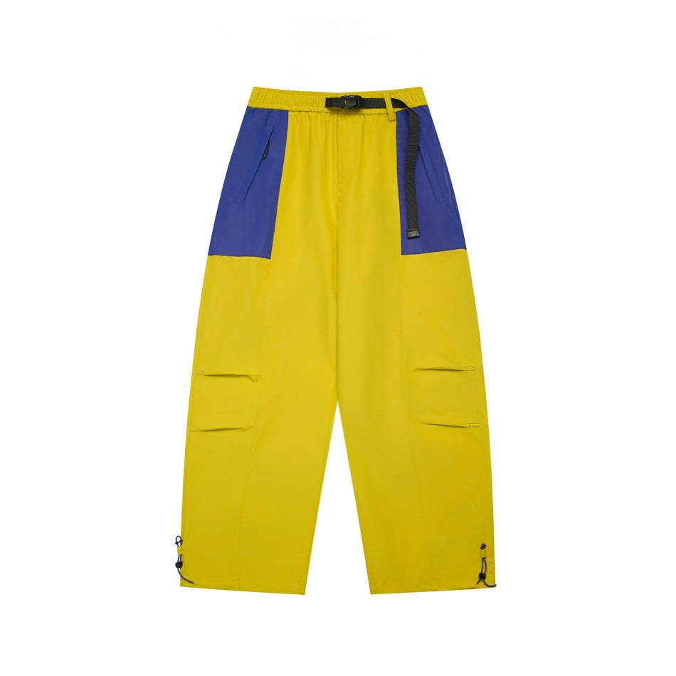 Yellow wide-leg pants with blue-violet hip panels, black buckle belt, thigh pleats and drawcord hems, flat front view
