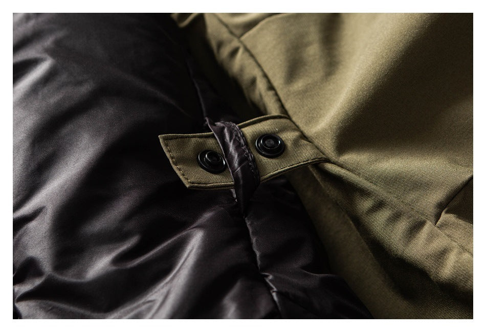 Close-up of black jacket fabric beside olive fabric, with a two-snap olive tab.