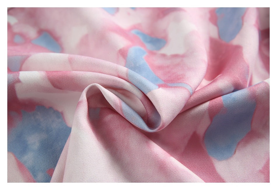Close-up of softly draped fabric with a pink, white, and blue abstract print.