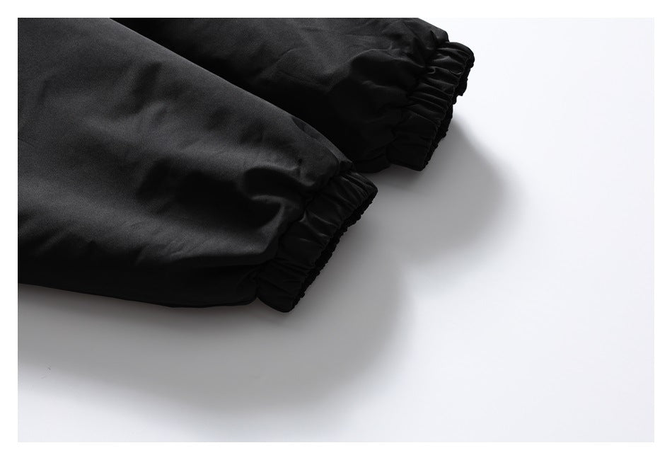Close-up of two gathered elastic cuffs on the black jacket sleeves.